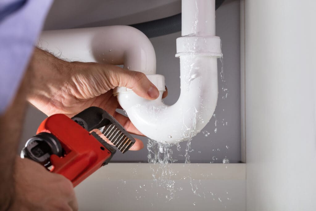 plumber fixing a leaking pipe